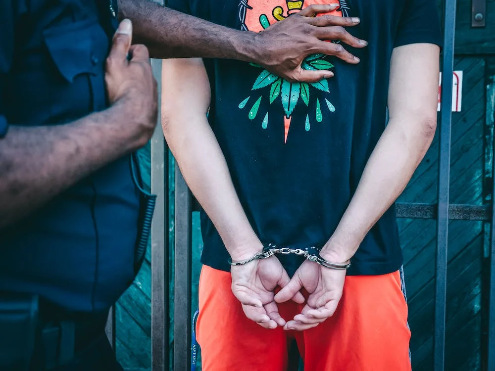 The police arresting a man in handcuffs